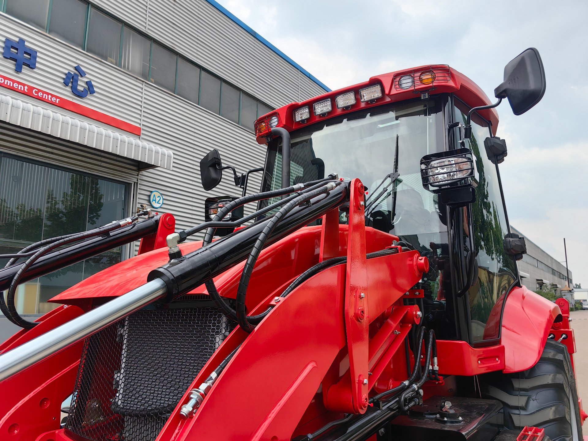 AOLITE backhoe loader at the factory development center, photographed before export configuration