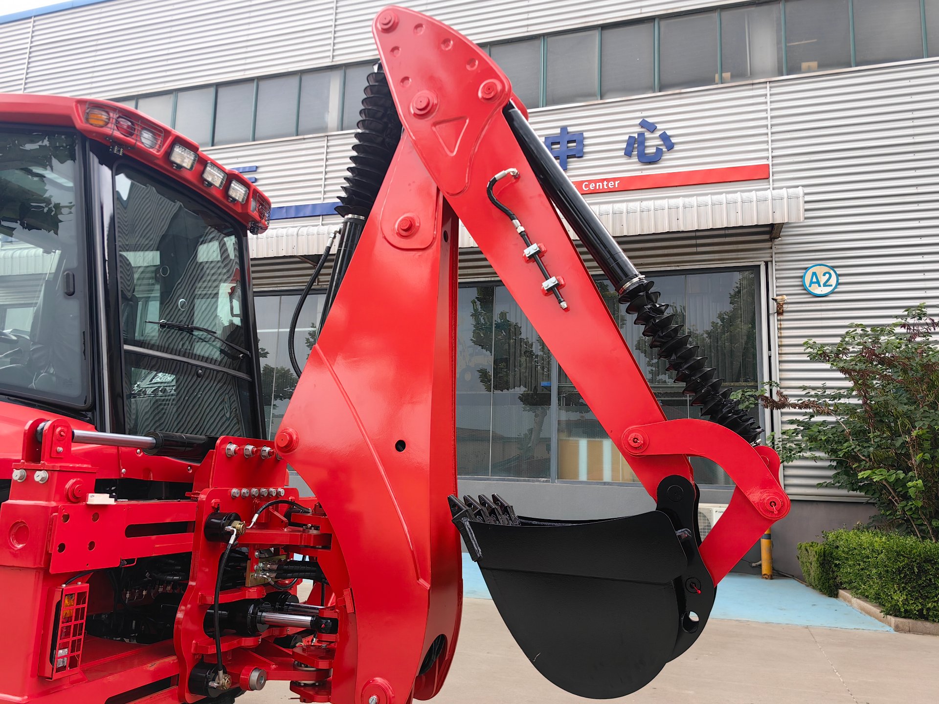 AOLITE backhoe loader backhoe arm and bucket detail at the factory