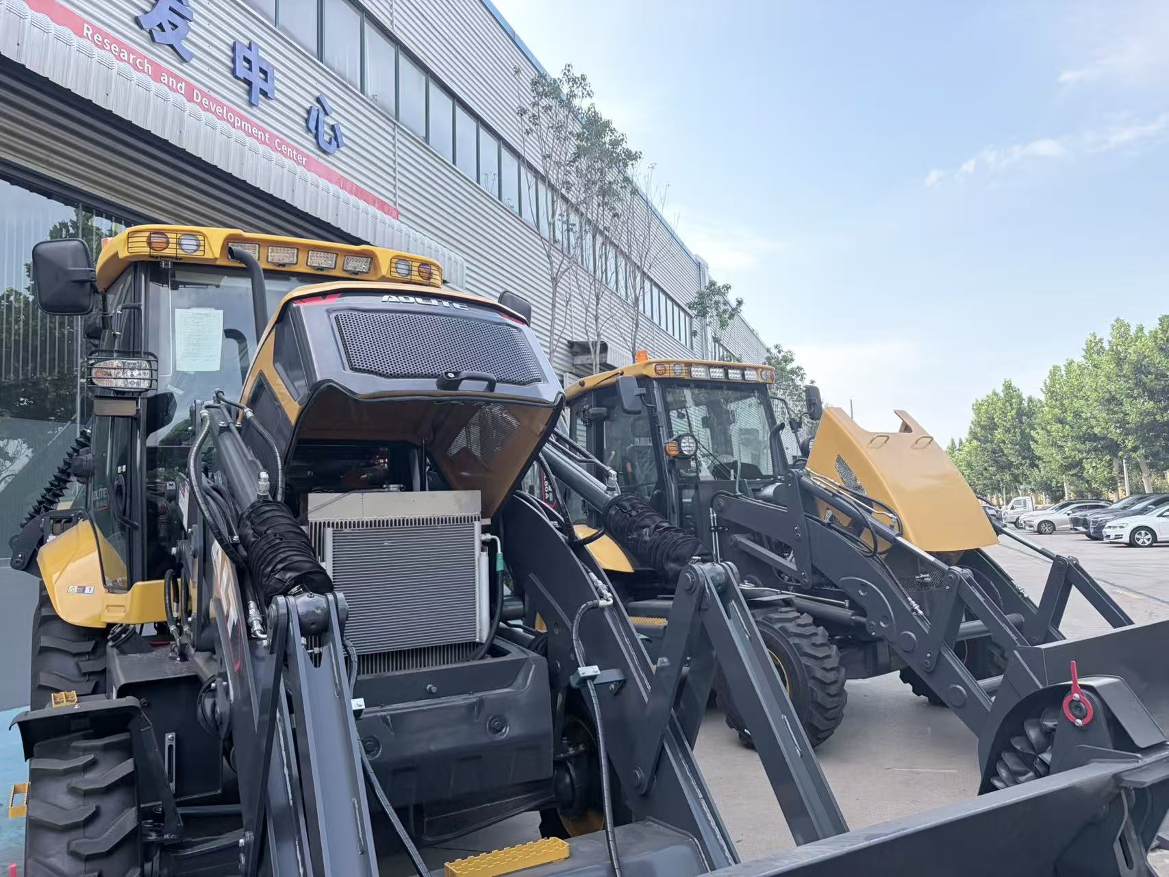 Backhoe loaders lined up outside the research and development center