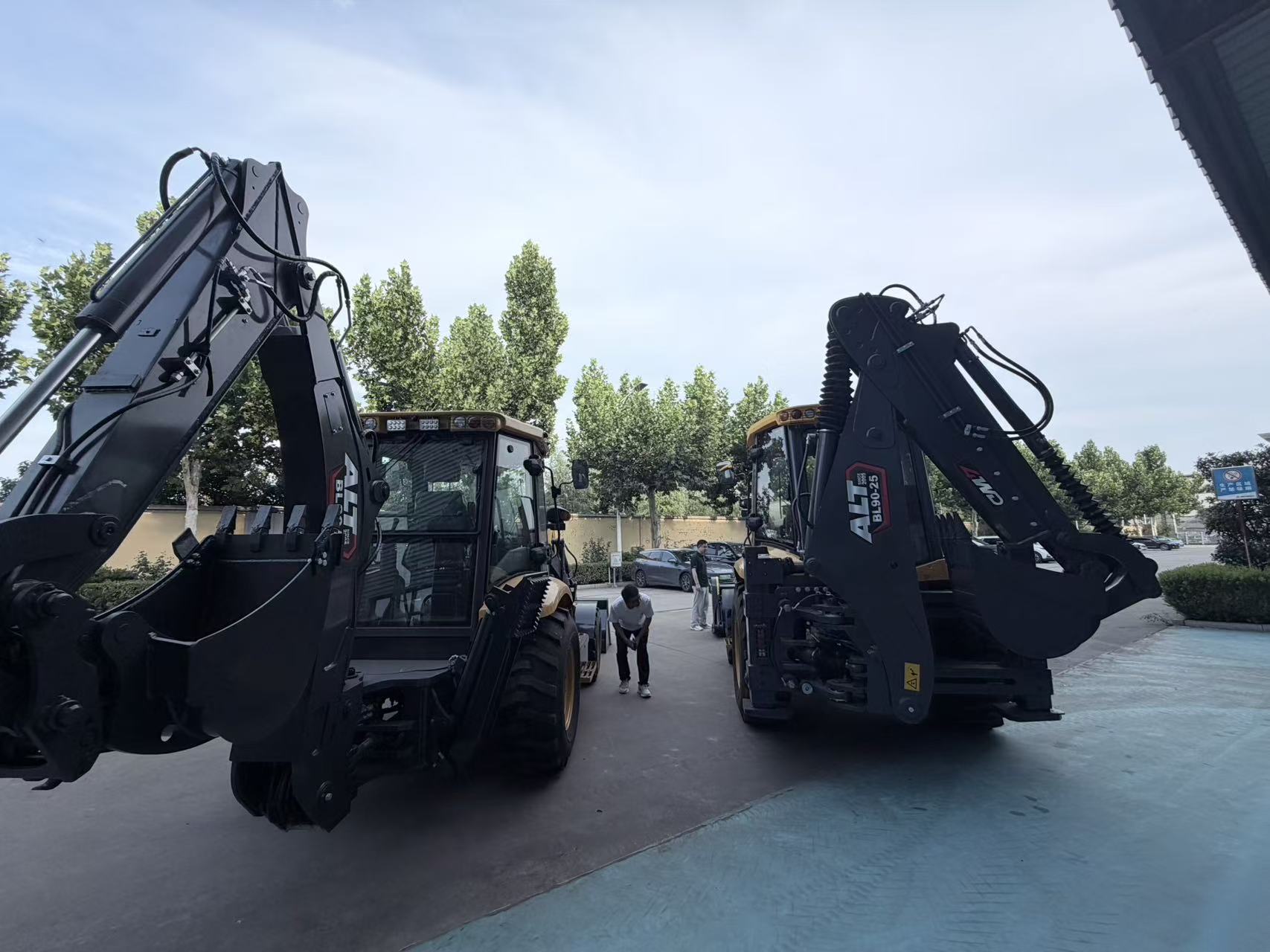 Two backhoe loaders side by side in the yard