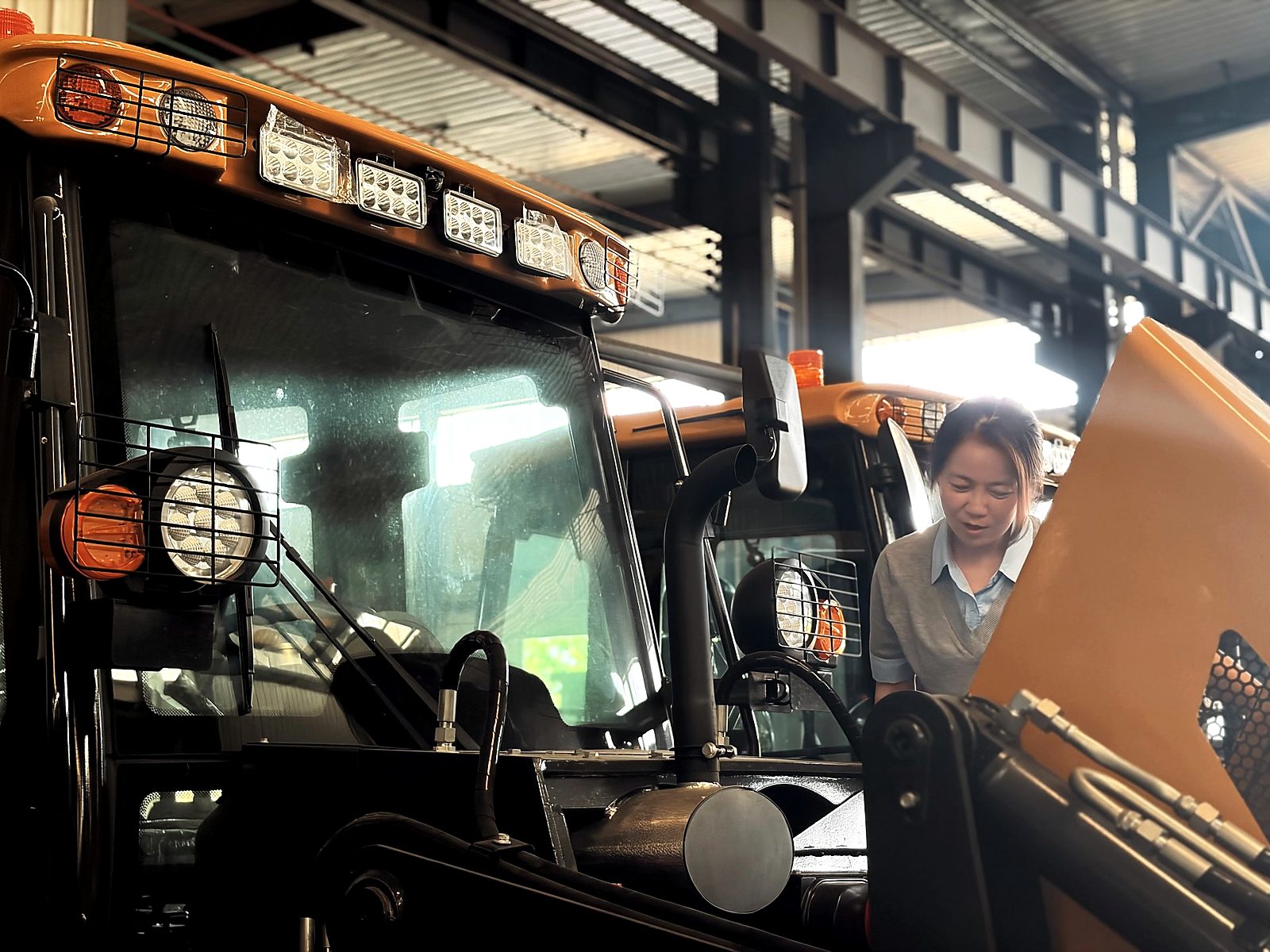 Engine and cab inspection on a backhoe loader during factory quality control