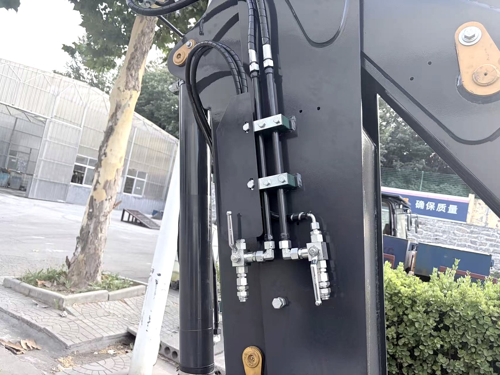 Hydraulic cylinder and hose connections on a backhoe loader