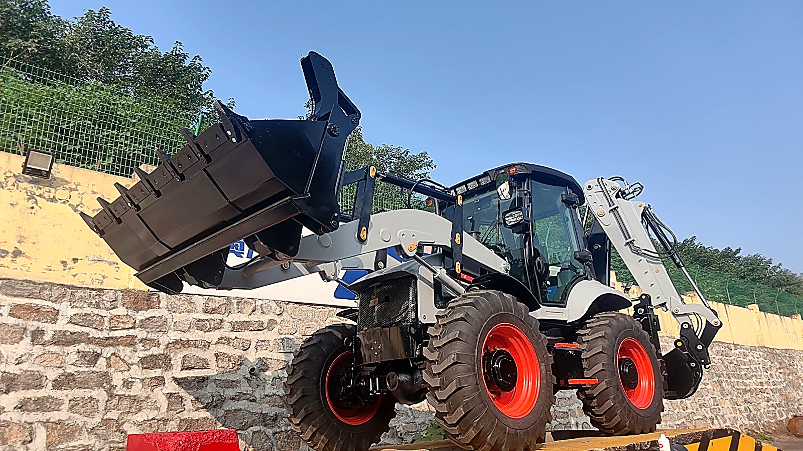 Hydraulic system quality control inspection on a backhoe loader at the factory before dispatch