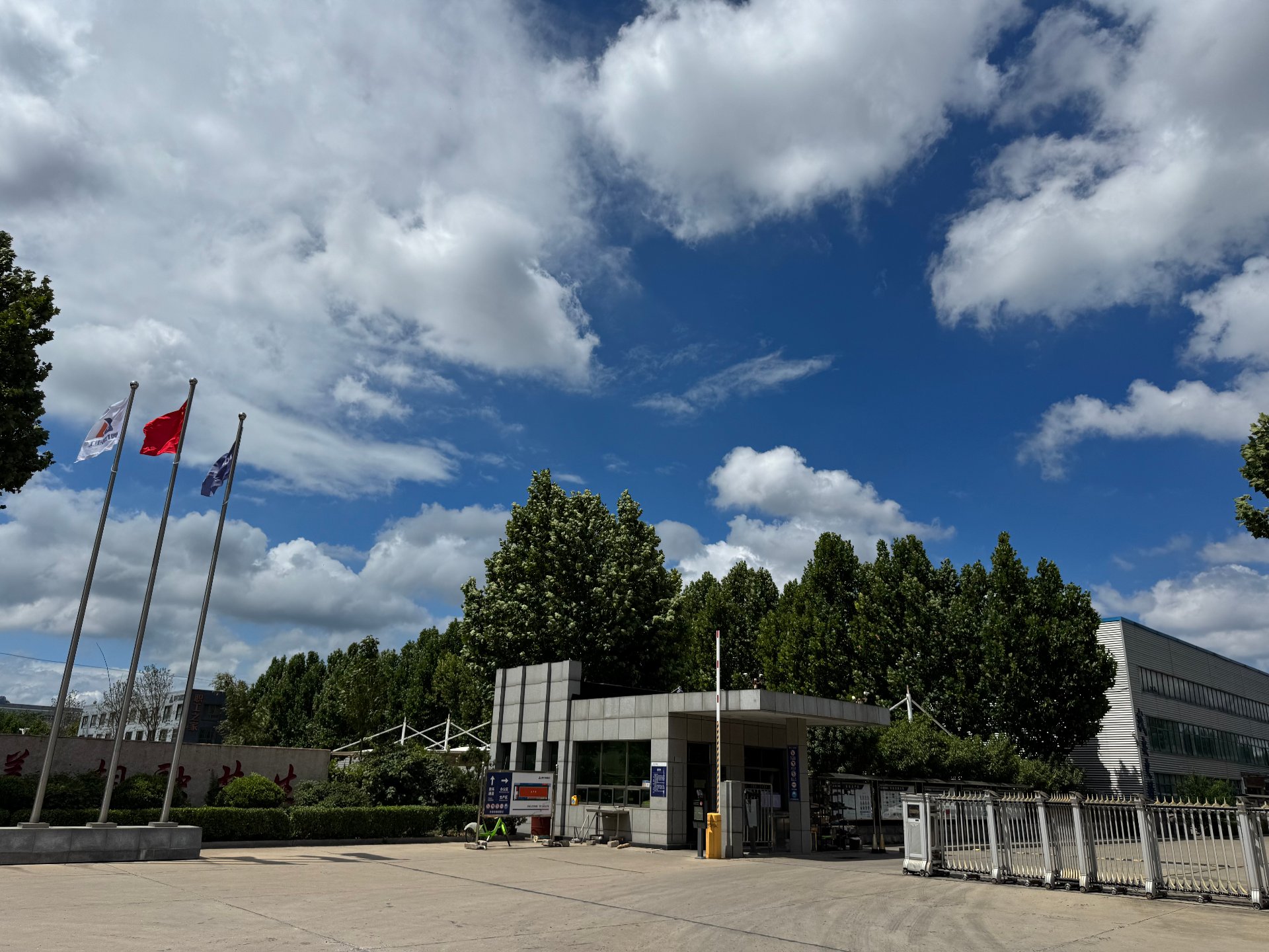 A heavy equipment manufacturer facility in China, front gate view on a clear day, photographed by Vivian