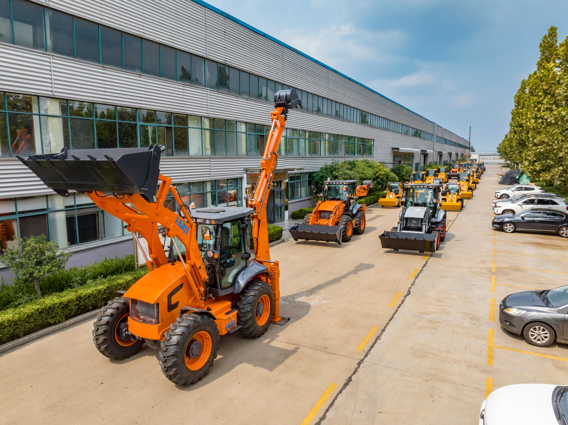 Aolite factory yard with backhoe loaders lined up ready for export, photographed by Vivian
