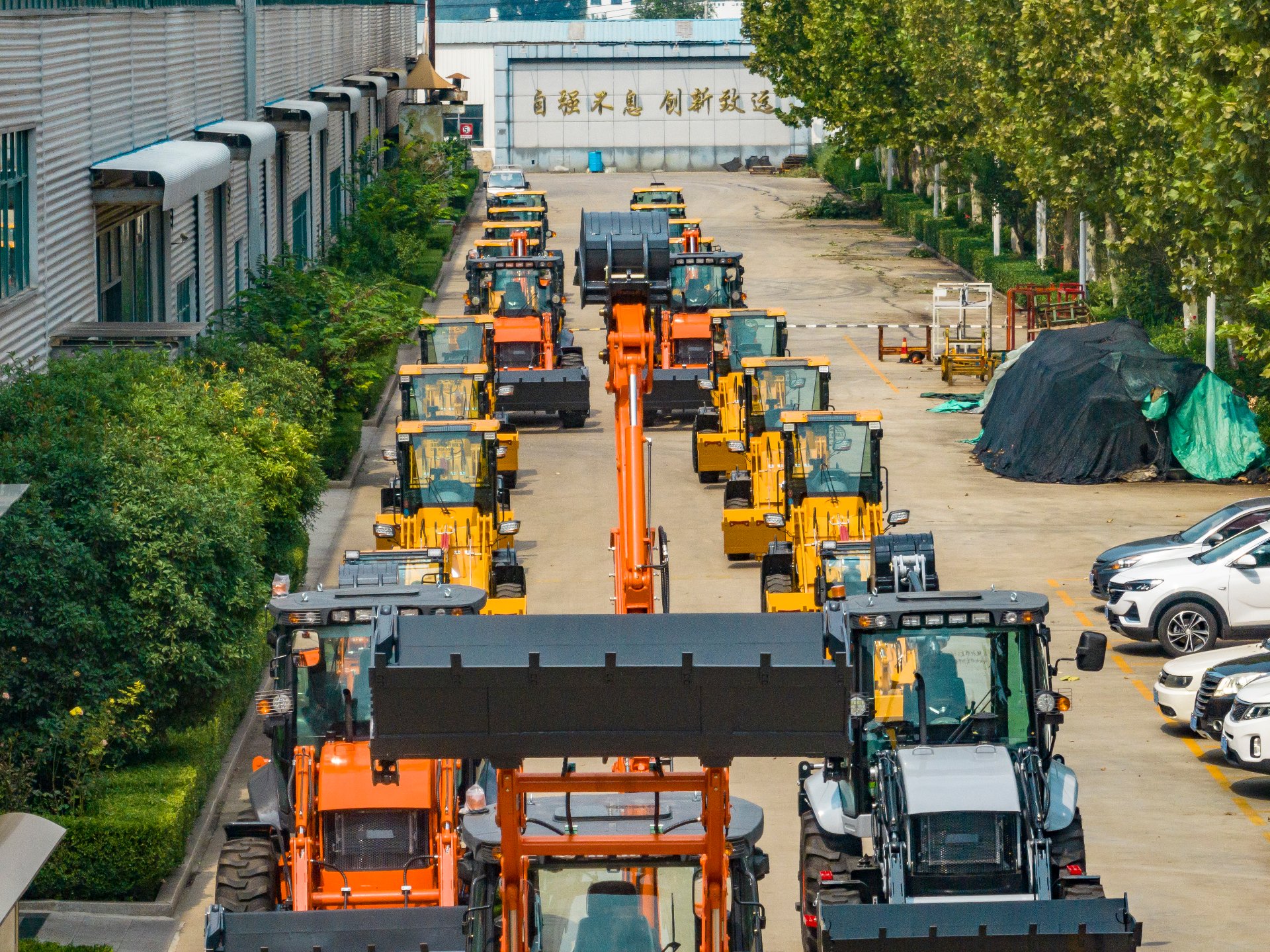 Aolite factory aerial view with backhoe loaders lined up before shipping, photographed by Vivian